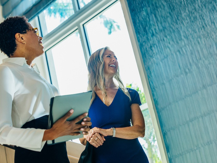 Two women talking inside an office building