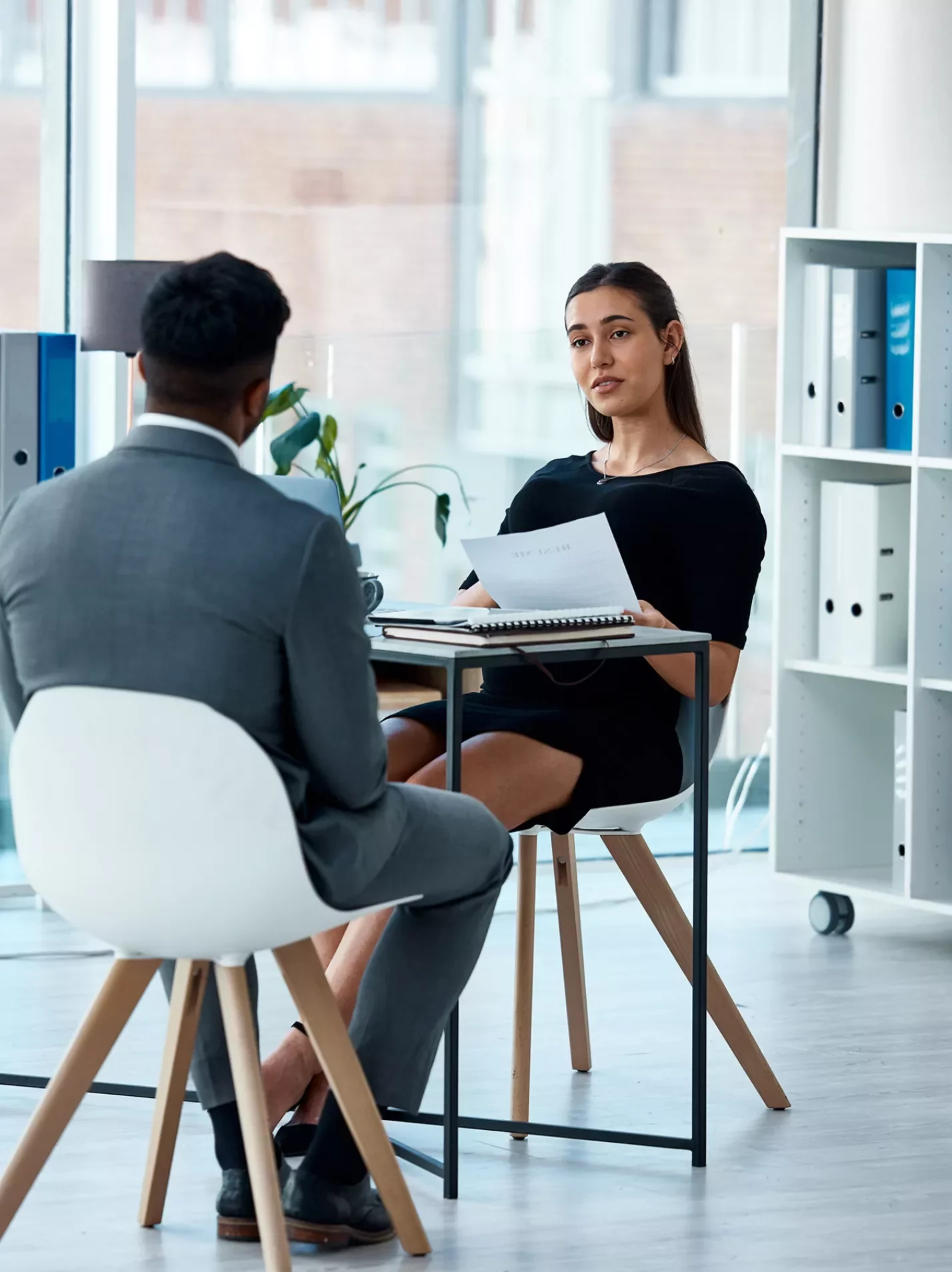 Man and woman in a casual office setting having a conversation across a table