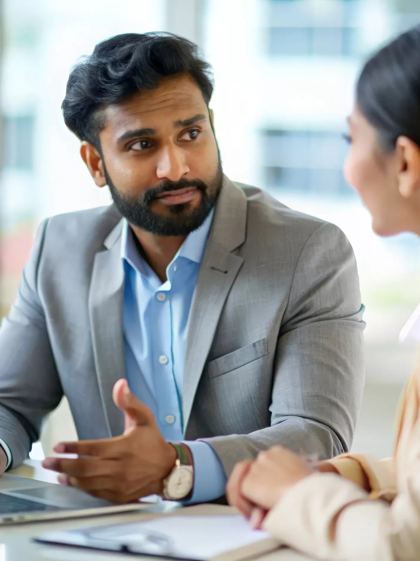 Man and woman talking in front of an open laptop