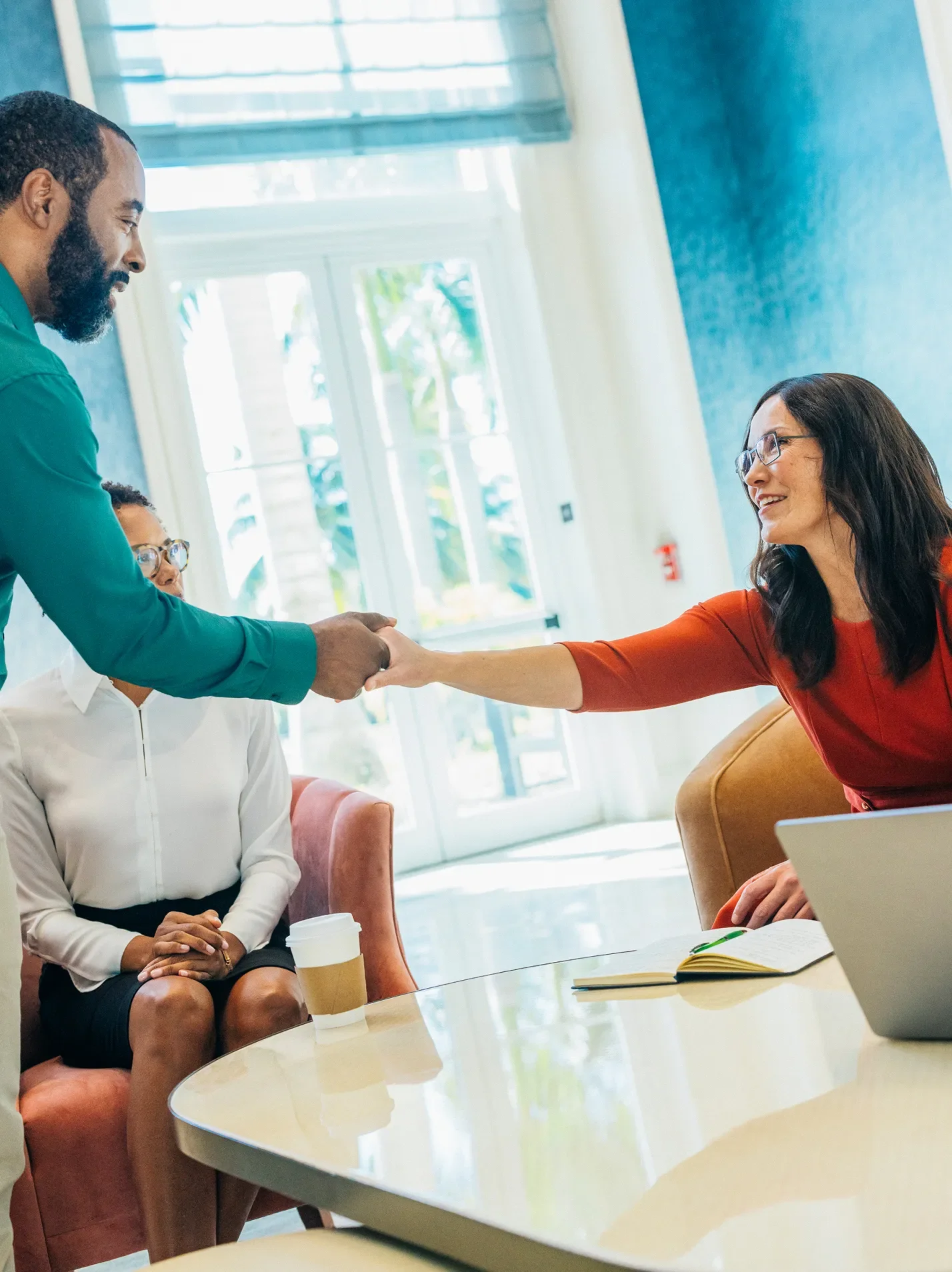 Woman and man shaking hands across a table