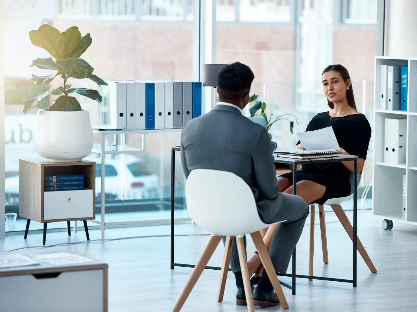 Man and woman in a casual office setting having a conversation across a table