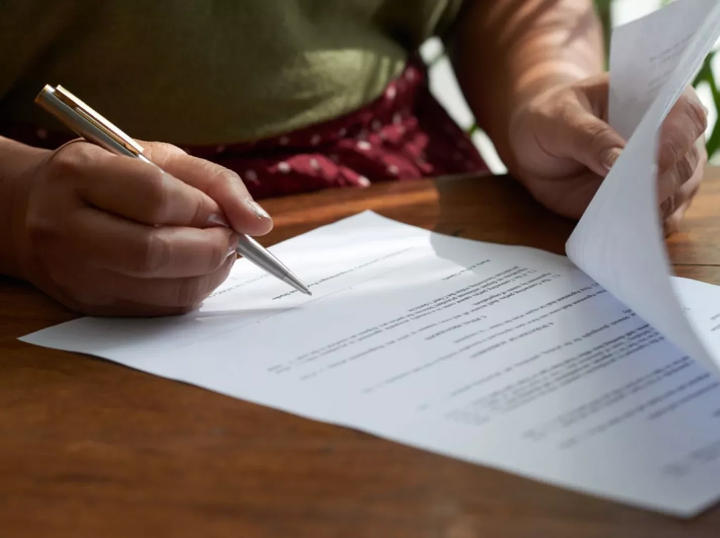 executive compensation woman's hands signing contract document
