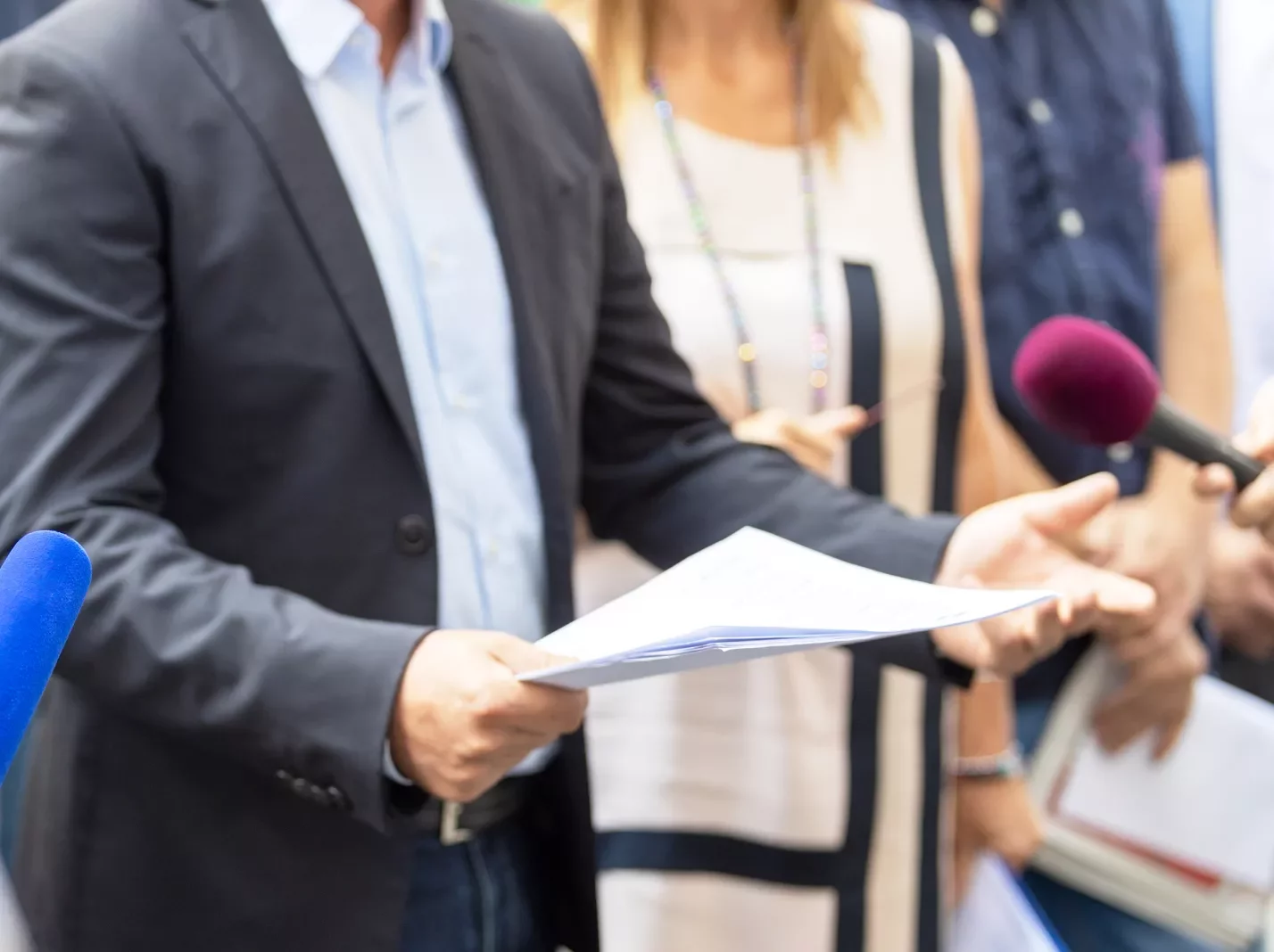 Person at a microphone reading a statement from a piece of paper