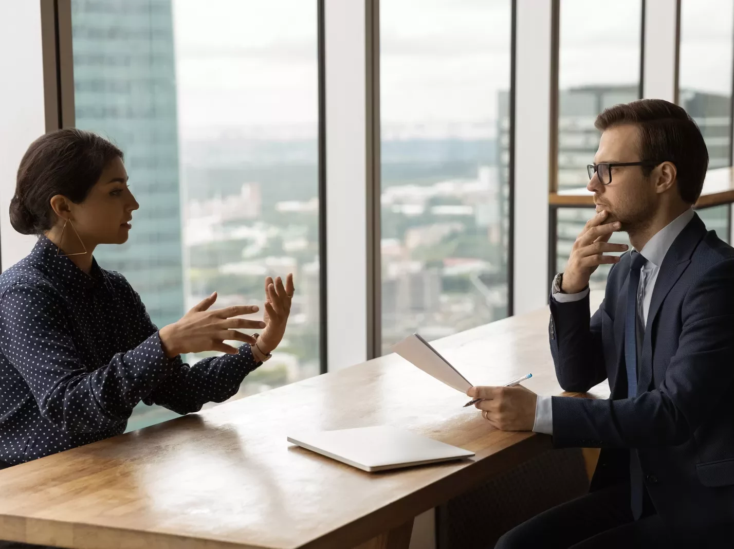 Man and woman sitting across a table in serious conversation