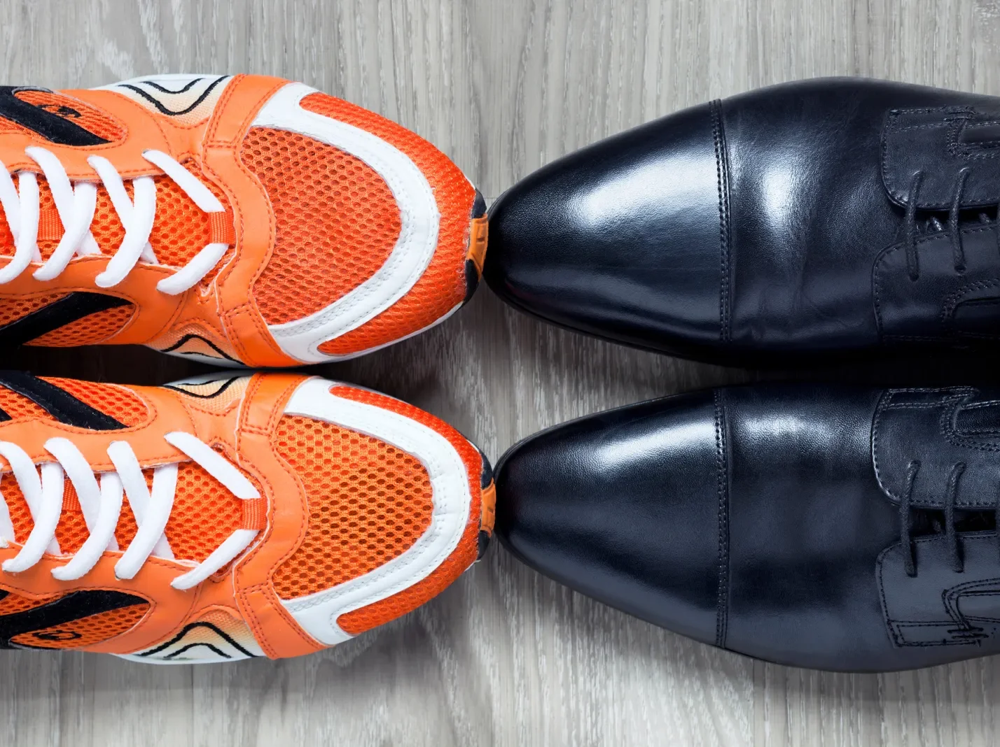 An overhead view of athletic shoes and business shoes