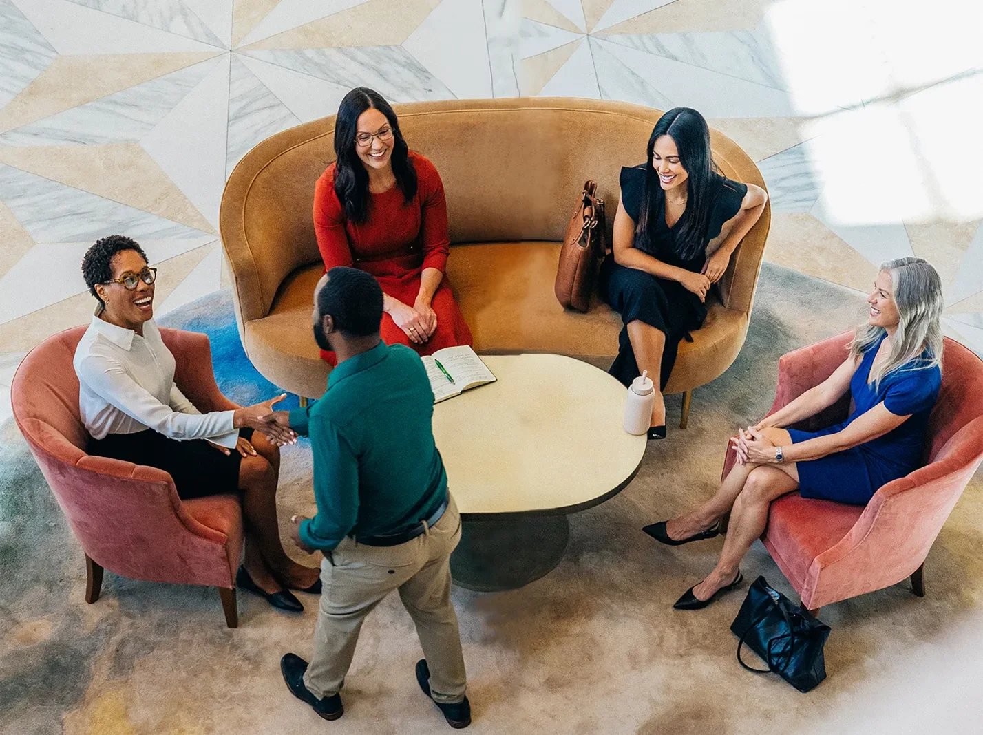 Overhead view of business people in a lobby meeting around a table