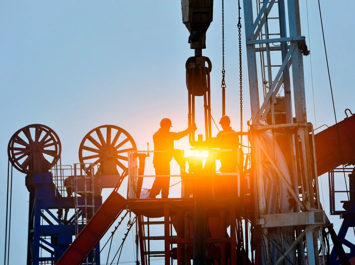 Two workers standing on equipment