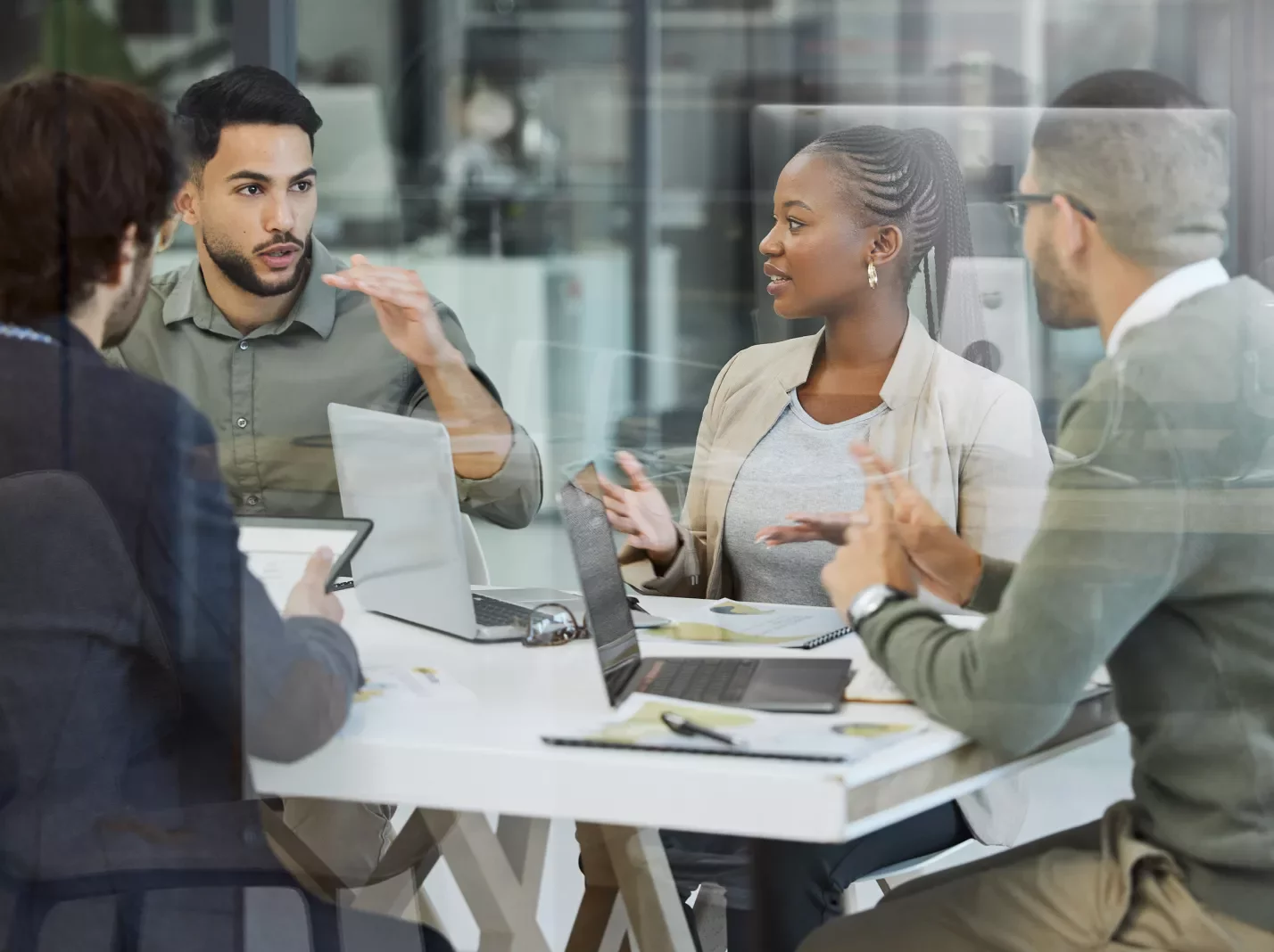 Business people meeting around a conference table with a laptop in conversation