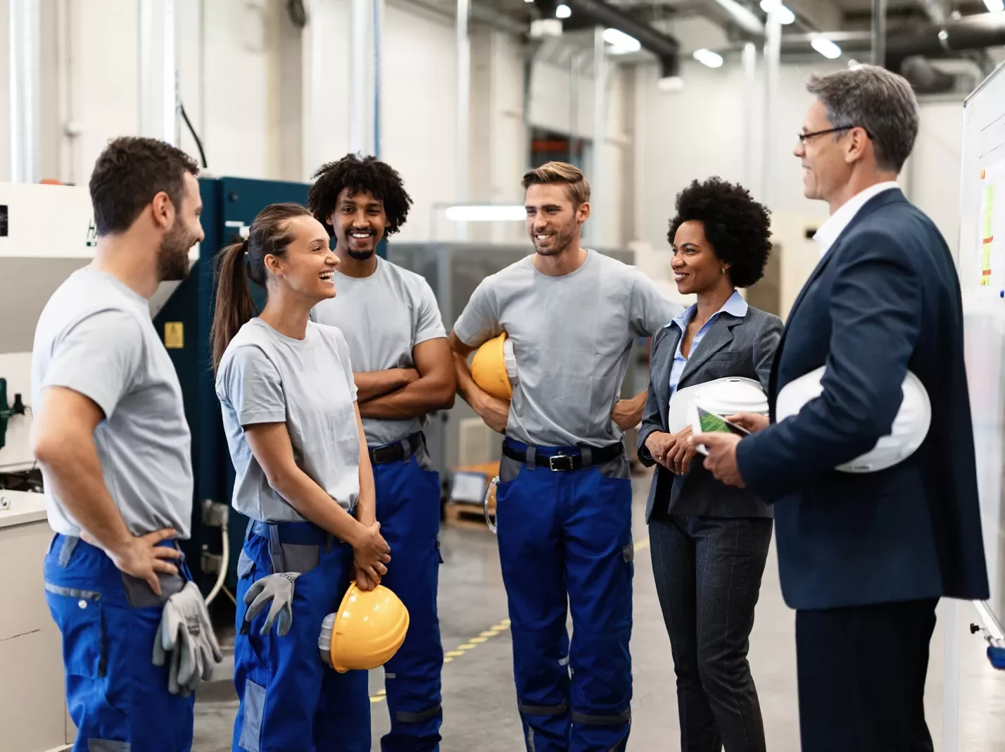 Workers and management having a conversation holding hard hats