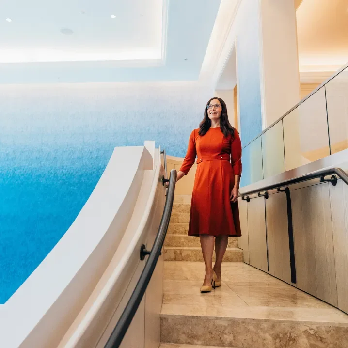 A woman in a red dress standing on a staircase