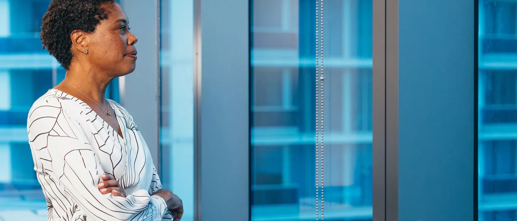 Woman in an office building looking out the window