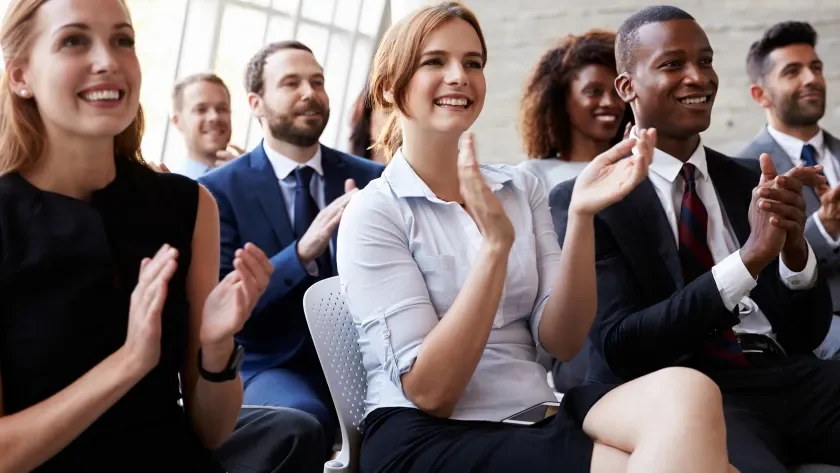 seated attendees applauding at a live event