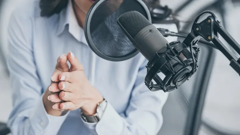 Woman speaking into a podcasting microphone