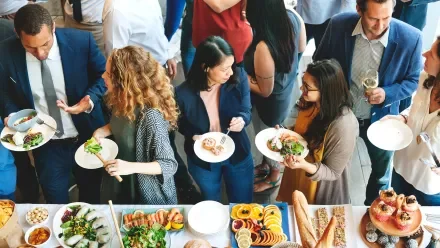Attendees at a live event mingle and enjoy lunch