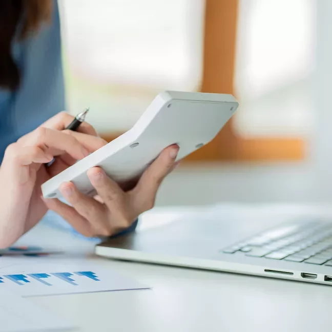 Hands holding a calculator auditing