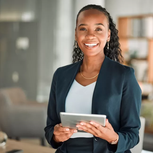Woman in suit holding a tablet in an office