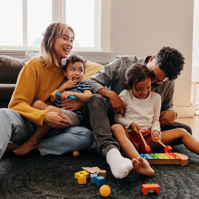 A man and a woman with small children playing on the floor