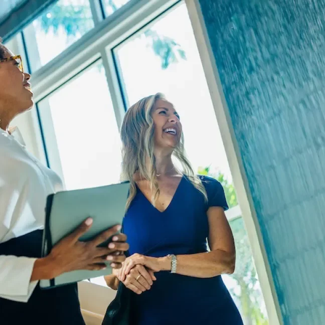 Two women talking inside an office building