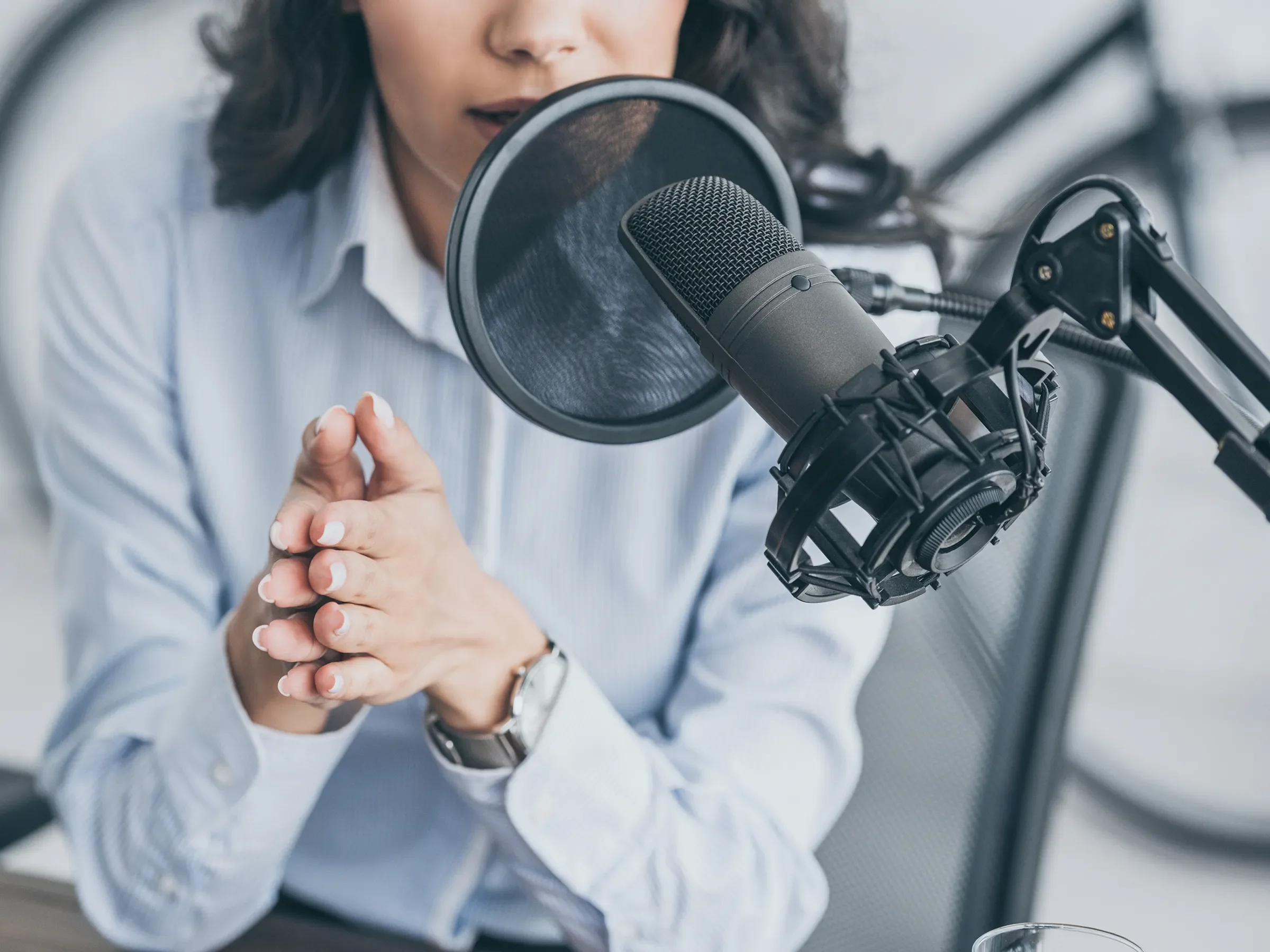 Woman speaking into a podcasting microphone